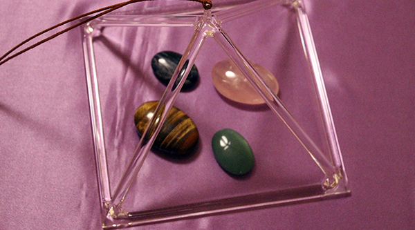 Klangpyramide mit vier Handschmeichlern auf lila Seidentuch