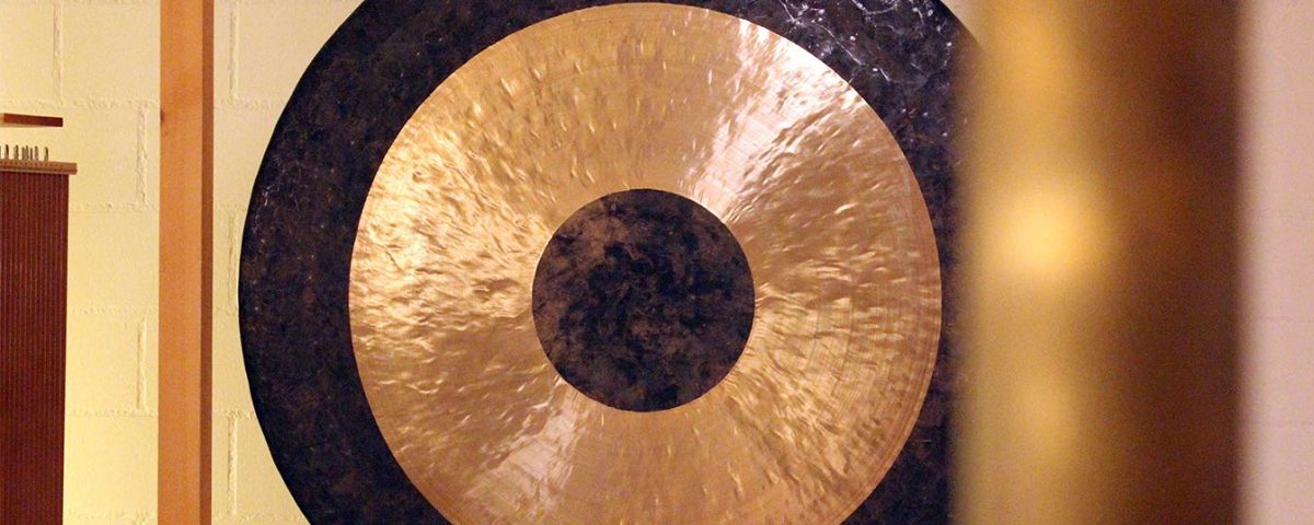 Close Up Gong mit unscharfer Klangröhre im Vordergrund